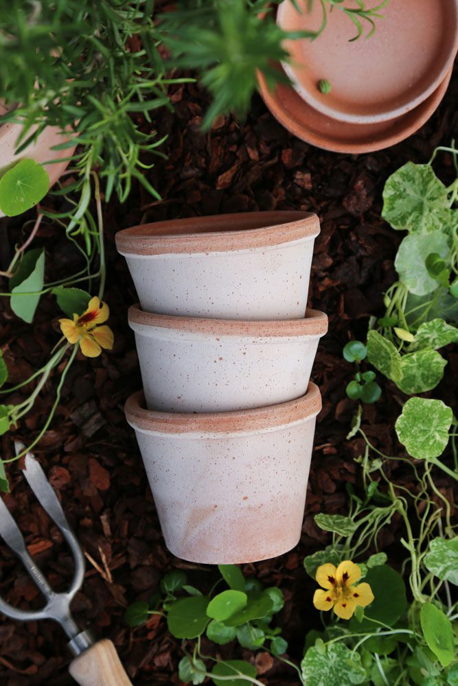 Stacked grey pots on garden soil
