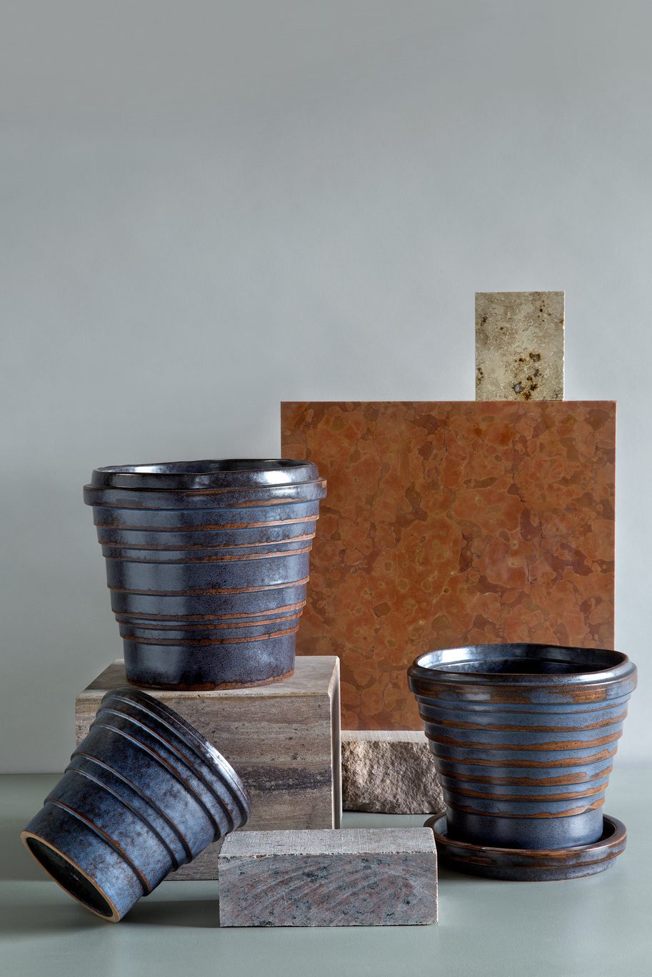 Blue-brown glazed pots organized with raw material.