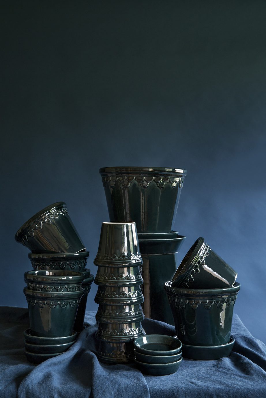 Collection of glazed petrol blue pots in different sizes.