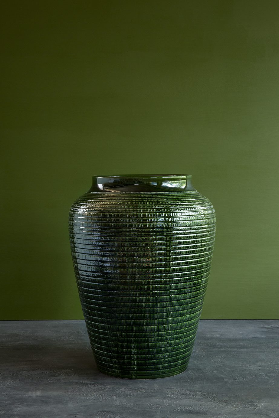 Large green empty vase with pattern on green background