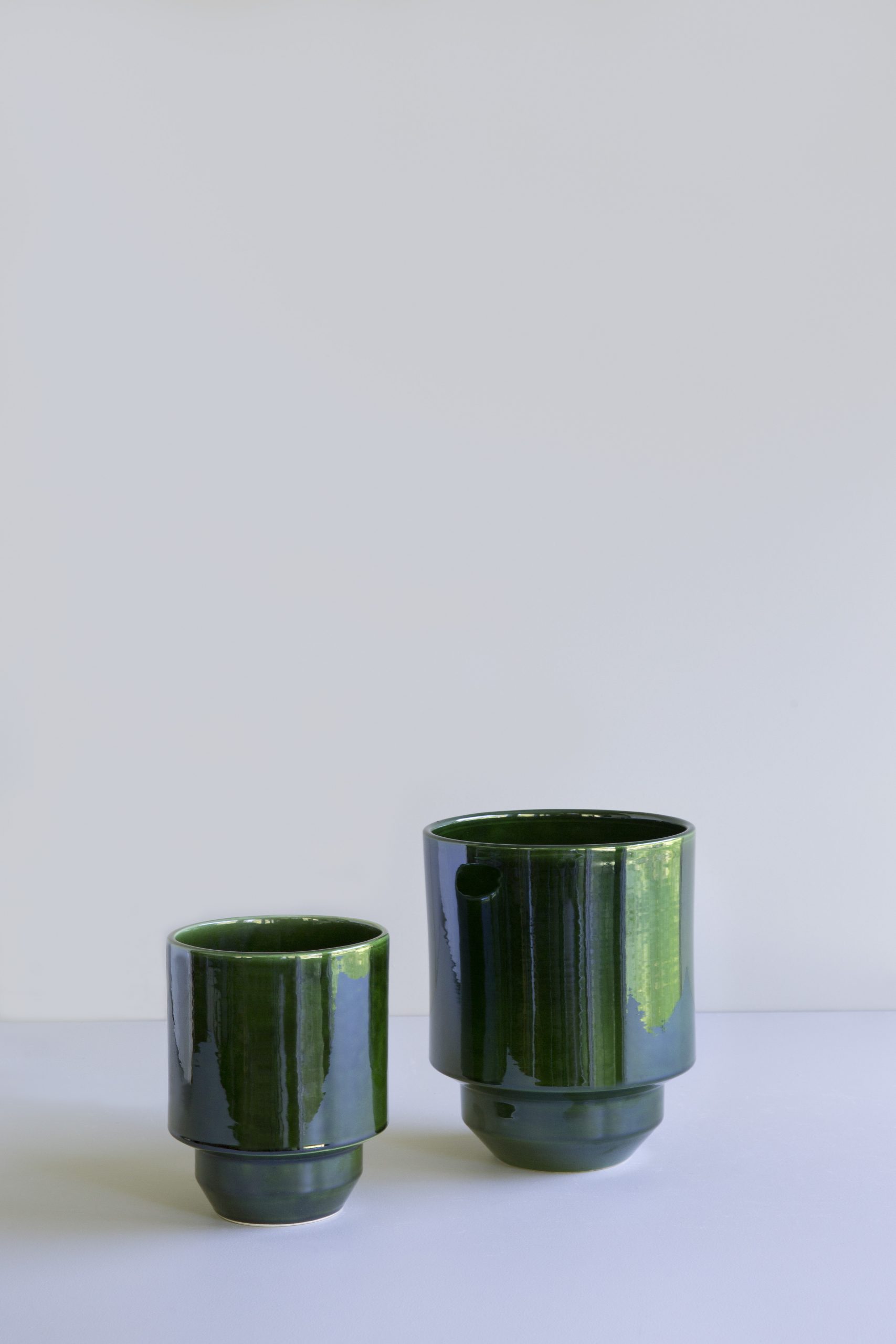 Empty green cover pots in two different sizes.